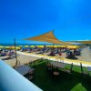 Spiaggia con ombrelloni gialli e tavoli sotto copertura.