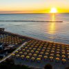 Spiaggia all'alba con ombrelloni gialli.