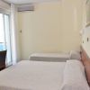 Camera da letto con due letti singoli, scrivania, una TV e aria condizionata.
