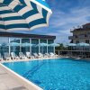 Piscina all'aperto con lettini e ombrelloni blu e bianchi.