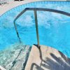 Piscina con gradini sommersi e acqua scintillante, ombreggiata dai bordi.