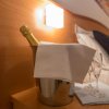 Bottiglia di spumante e calici su un comodino.