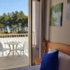 Stanza con vista su un balcone e alberi.