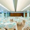 Ampia sala da pranzo con tavoli apparecchiati, ambientazione luminosa.