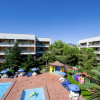 Spazi esterni con piscine, lettini e ombrelloni vicino a edifici.