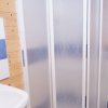 Bagno con lavabo, specchio, cabina doccia vetrata e WC con pareti in legno.