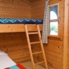 Stanza con letto a castello in legno e finestre con tende a quadretti.