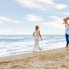 Famiglia felice gioca sulla spiaggia vicino al mare.