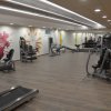 Palestra luminosa con attrezzi per allenamento e decorazioni murali colorate.