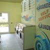 Interno di una lavanderia self-service con lavatrici e panchina.