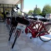 Una fila di biciclette rosse parcheggiate su un marciapiede tile bianco.
