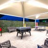 Area coperta con giochi da tavolo e sedie, ambiente serale illuminato.