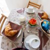 Tavolo apparecchiato per colazione con croissant, latte e biscotti.