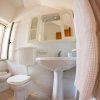 Un bagno con sanitari bianchi, lavabo, e specchio, vista grandangolare.