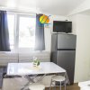 Soggiorno moderno con tavolo, divano, frigorifero e TV a parete.
