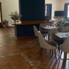 Sala con tavoli e sedie moderne, TV sullo sfondo.