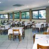 Ristorante ampio con tavoli apparecchiati e numerose finestre.