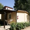 Esterno di un bungalow con veranda e piante.