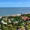 Vista aerea della spiaggia e del mare con una struttura immersa nel verde vicino alla riva.