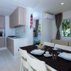 Interni luminosi di un bungalow con cucina, tavolo apparecchiato e divano.