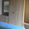 Camera con armadio in legno e copriletto blu.