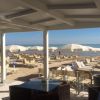 Sedie e ombrelloni bianchi su spiaggia sabbiosa.