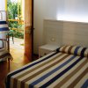 Camera con letto a righe, porta aperta sul giardino.