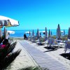 Spiaggia con file di ombrelloni chiusi.