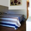 Camera da letto con letto a righe e quadro di rose.