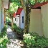 Sentiero tra bungalow con alberi e arbusti verdi.