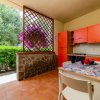Cucina con mobili arancioni e vista sul giardino.