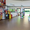 Un minimarket con scaffali pieni di snack, gelati e giocattoli colorati.