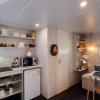 Cucina compatta con mensole aperte, tavolo da pranzo.