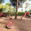 Parco giochi con scivoli, giostra e giochi per bambini.