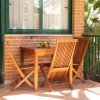 Tavolo in legno con due sedie su un balcone piastrellato.