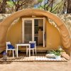 Una tenda moderna con veranda, tavolo, sedie e decorazioni all'esterno.
