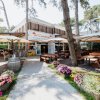 Un ristorante all'aperto tra gli alberi con tavoli di legno e fiori colorati.