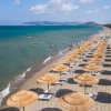 Spiaggia con ombrelloni e mare sullo sfondo.