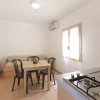 Tavolo con sedie vicino a finestra, cucina e divano accanto.