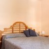 Una camera con letto matrimoniale, cuscini blu, comodini e un grande specchio con cornice in legno.