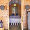 Interno di una cabina in legno con letto, lanterna blu e sedia a sdraio.