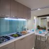 Cucina moderna con tavolo apparecchiato, vista su una camera.