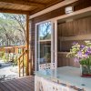 Tavolo con sedie e vaso di fiori su una terrazza, all'esterno di un bungalow immerso nella natura.