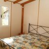 Camera da letto con letto matrimoniale e finestra che affaccia su un giardino.