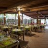 Una sala ristorante con tavoli apparecchiati e sedie sotto un soffitto in legno.