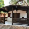Un bungalow marrone con veranda coperta.