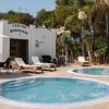 Area benessere all'aperto con piscine e sdraio.