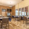 Sala da pranzo con tavoli blu e pareti in pietra.