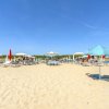 Una spiaggia con ombrelloni rossi e bianchi.