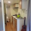 Cucina compatta con pavimento in legno e chitarra accanto al lavello.